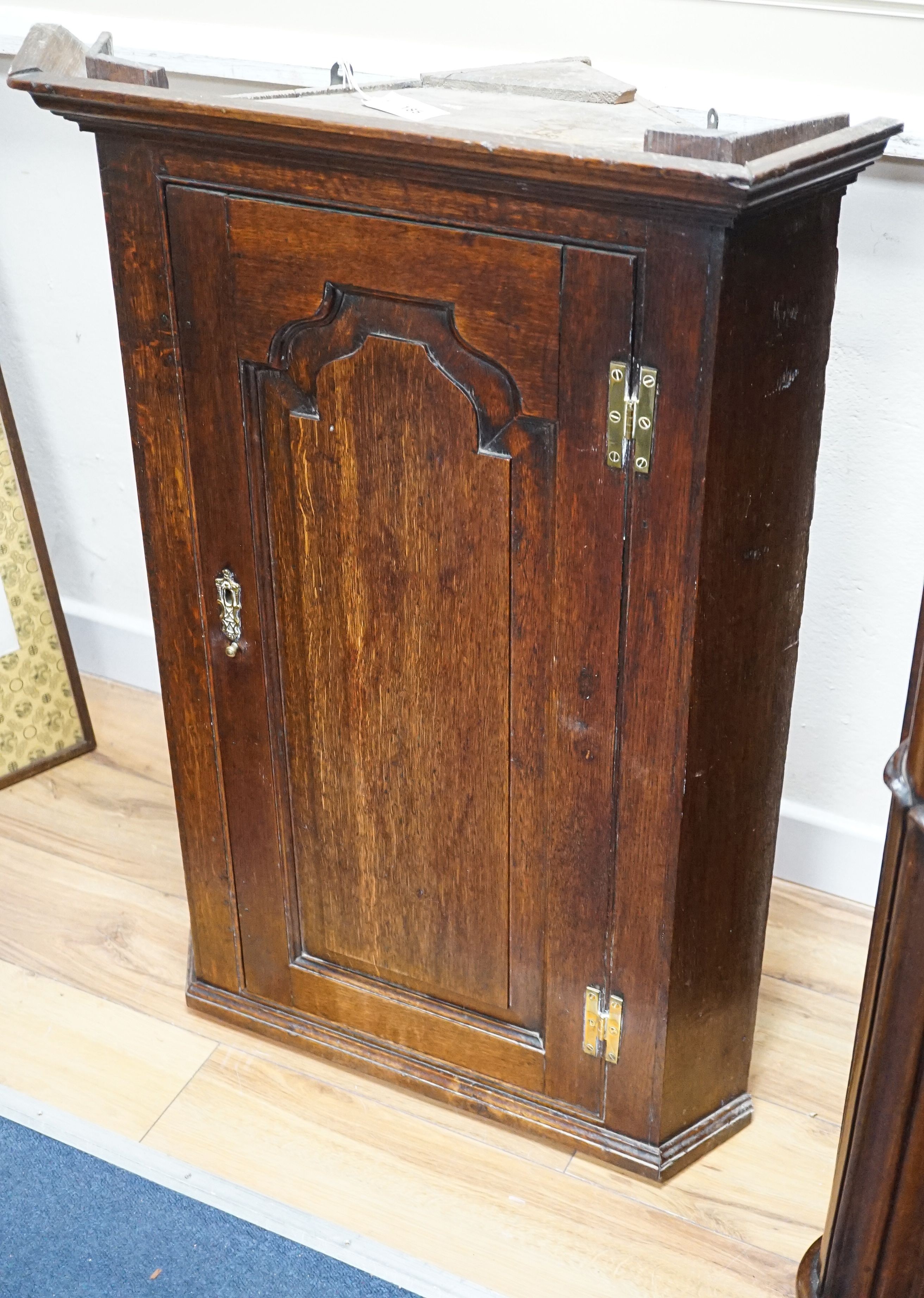 An 18th century panelled oak hanging corner cabinet, width 66cm, depth 43cm, height 93cm